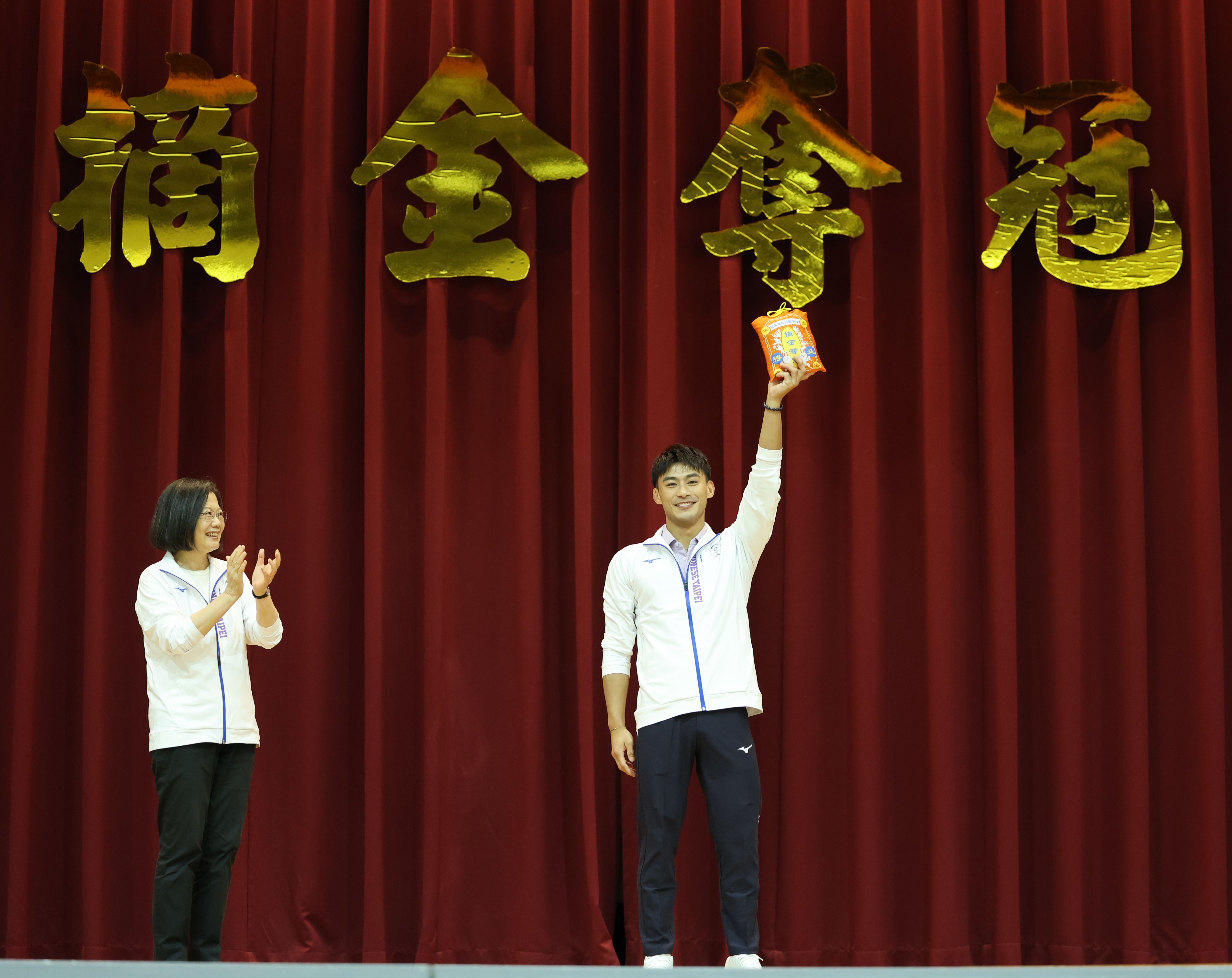 (圖)(附件照片3)1120916-3-蔡英文總統(左)於第19屆杭州亞運代表團授旗典禮致贈勝利御守，由柔道選手楊勇緯(右)代表受贈。