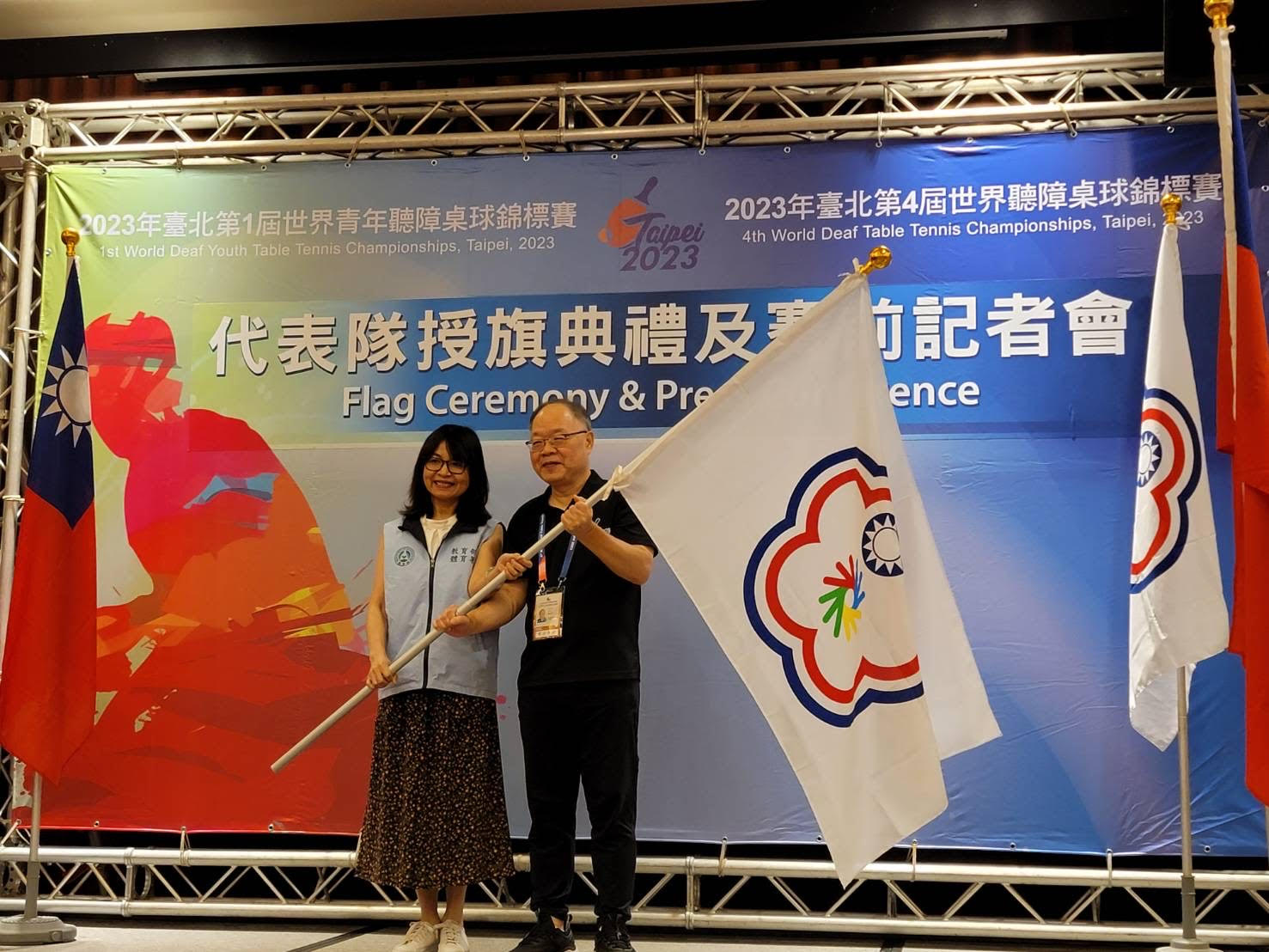(圖)Sports Administration Sports for All Division Senior Executive Officer Wang Fei-fan (left) presented the flag of the Chinese Taipei Deaf Sports Federation to a representative of Taiwan’s team for the 4th World Deaf Table Tennis Championship and 1st World Deaf Youth Table Tennis Championship.