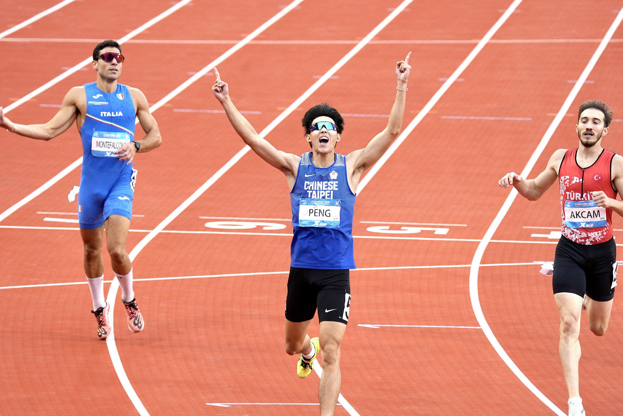 (圖)Track and field athlete Peng Ming-yang broke the finishing tape in the 400 meters hurdles with a time of 4262 seconds, raising his arms and calling out at the moment of victory.