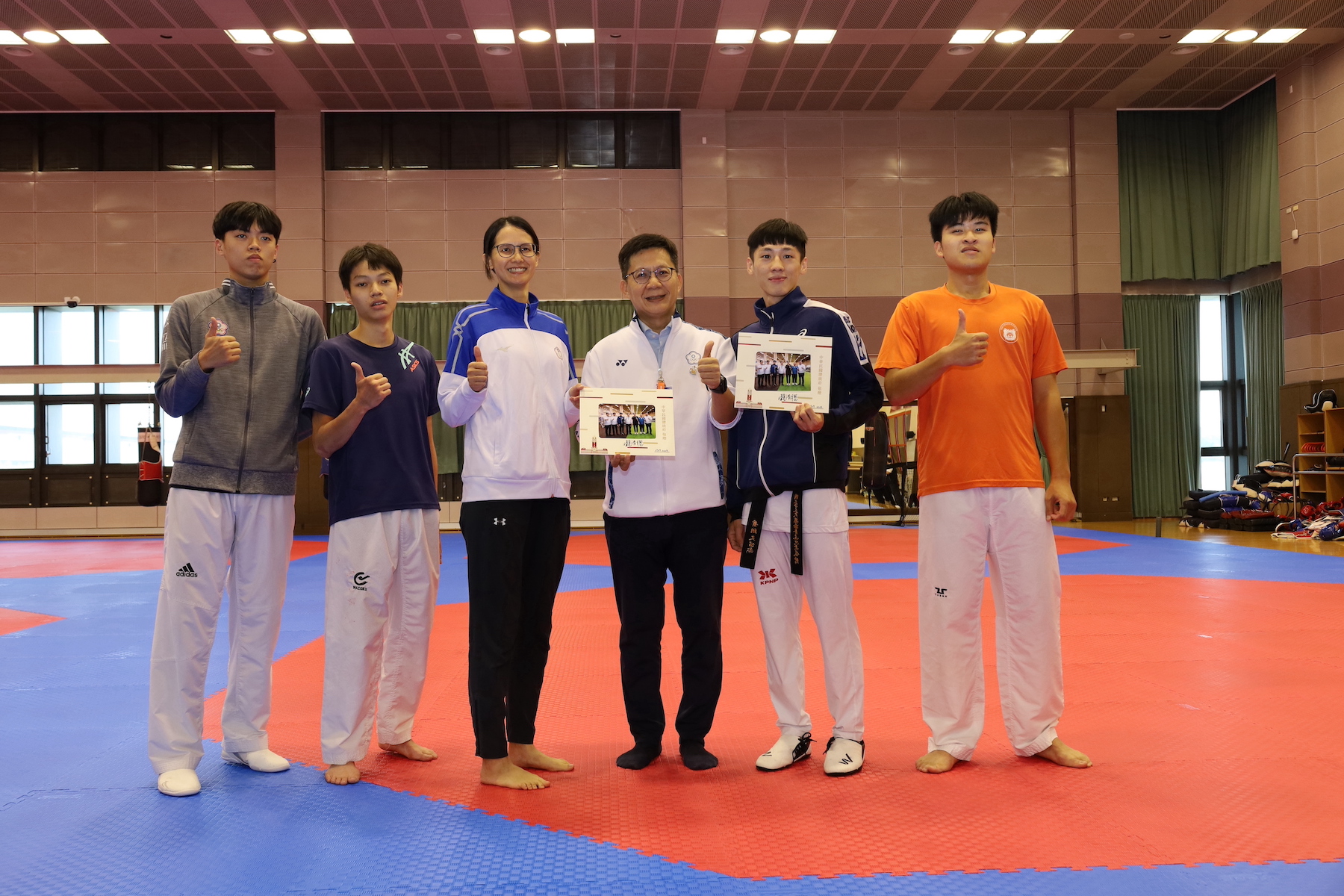 (圖)Deputy Minister of Education Zhang-Liao Wanjian (3rd from right) visited the National Training Center (NSTC) to show support for para taekwondo athlete Xiao Hsiang-wen (2nd from right). During the visit, he presented a photo of President Lai Ching-de with the training team from his previous visit to the NSTC.