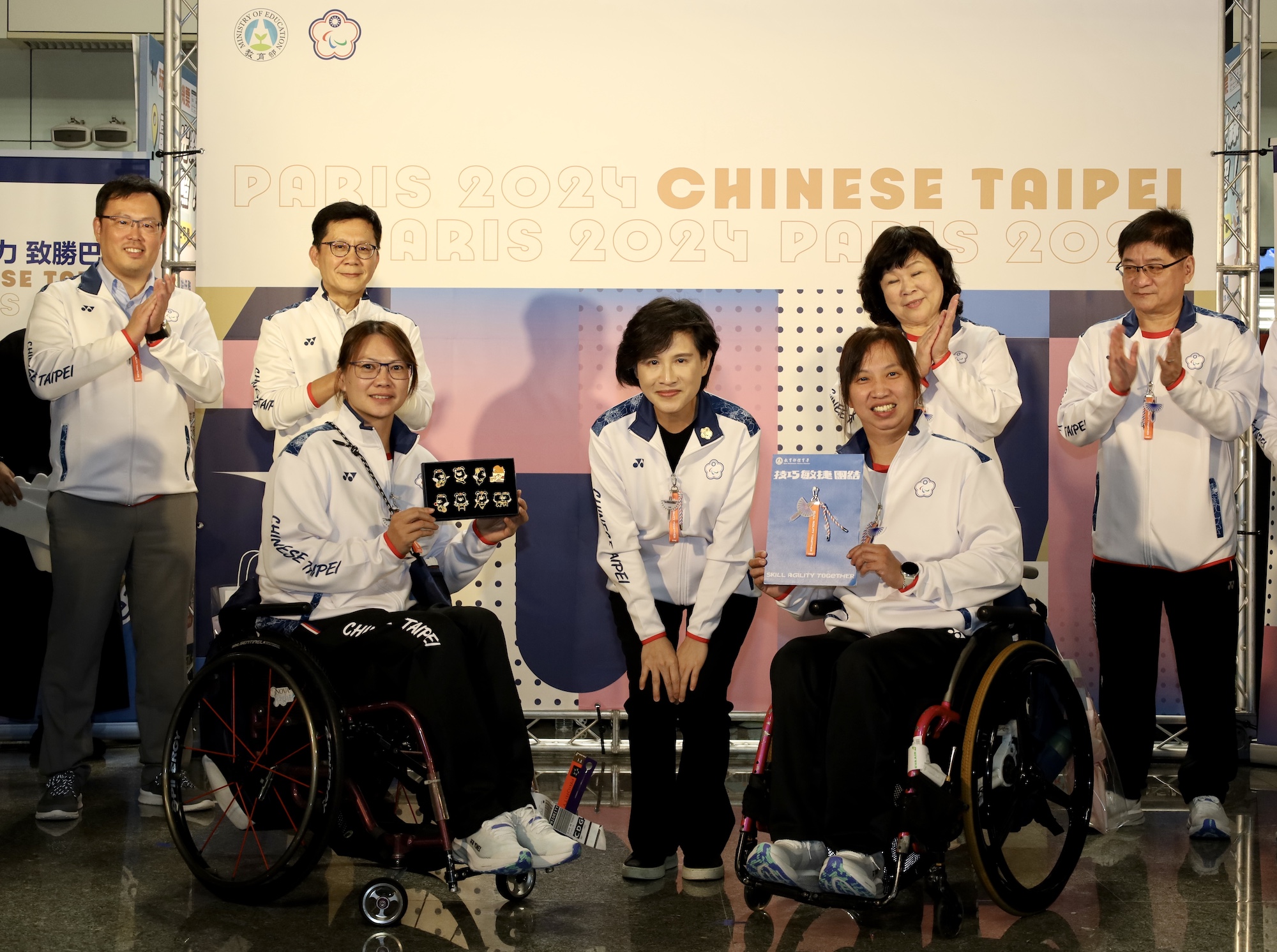 (圖)Vice Premier Cheng Li-chuin (middle) presented Taiwanese blue magpie pendants and Para black bear badges to members of the delegation. Badminton players Yang I-chen (left) and Hu Guang-chiou received the gifts on behalf of members of the delegation.