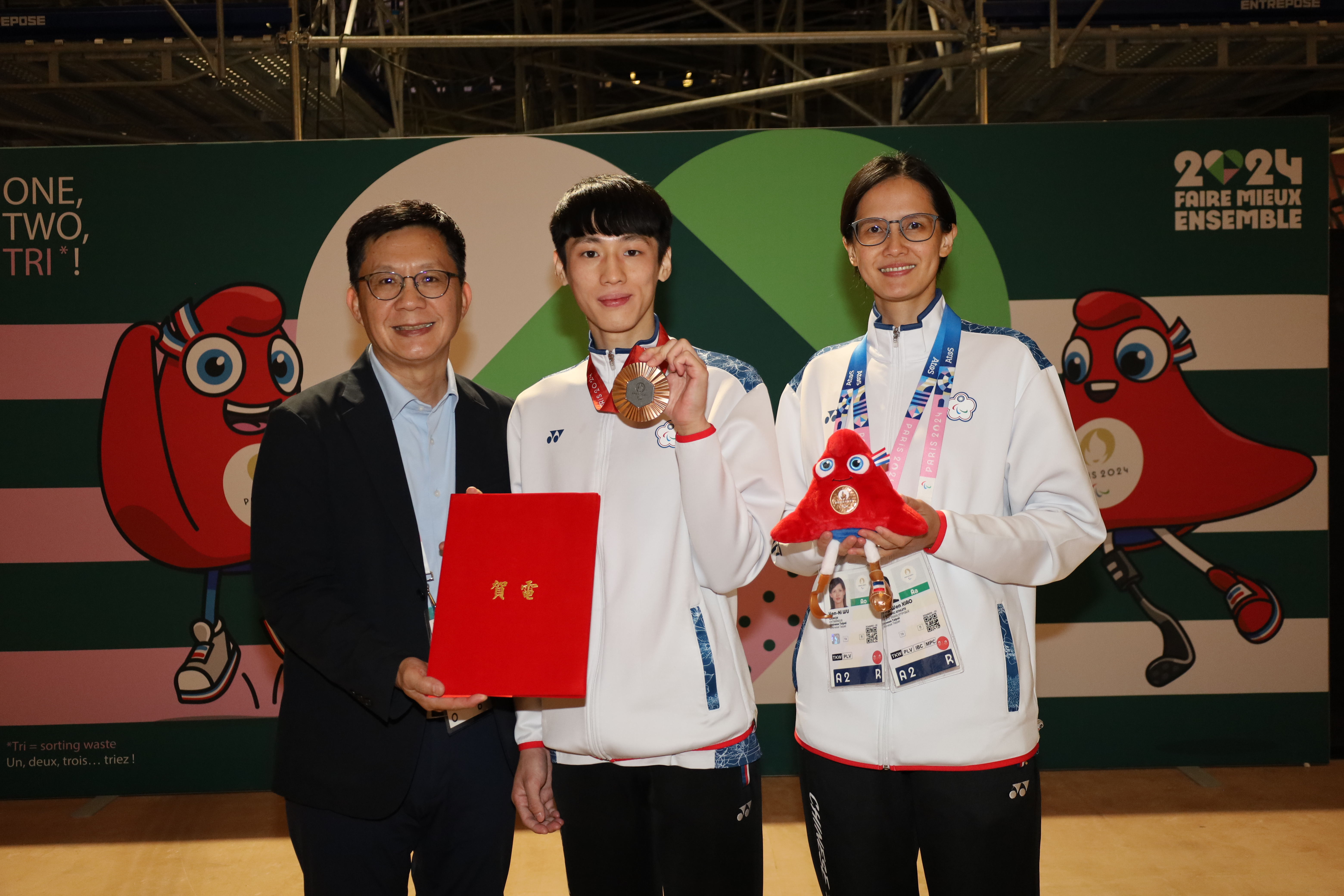 (圖)Political Deputy Minister of Education Chang Liao Wan-Chien (left) presented the presidential congratulatory message to athlete Hsiao Hsiang-wen (center) and coach Wu Yan-ni (right).